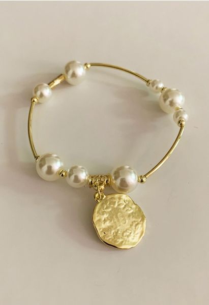 Brazalete de oro con perla y cabeza grabada