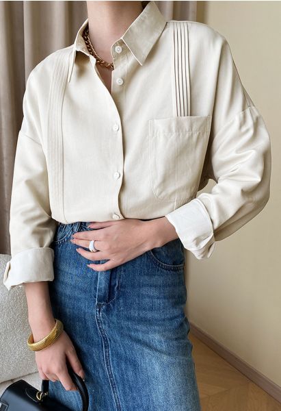 Elegante camisa con botones y detalle de pliegues en color crema