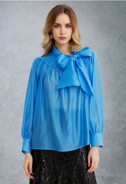 Encantadora camisa transparente con mangas abullonadas y lazo en azul
