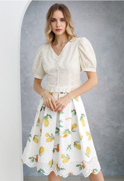 Falda plisada con borde festoneado y bordado con ojales y estampado de limones