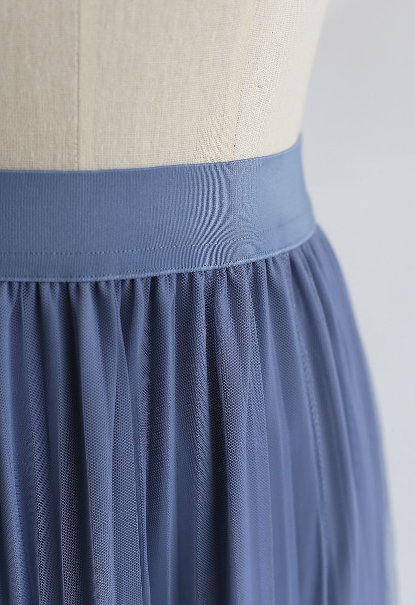 Falda midi plisada con dobladillo asimétrico de malla en azul