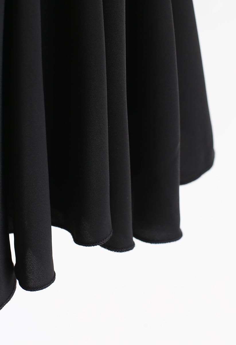 Top peplum asimétrico con mangas de murciélago en negro