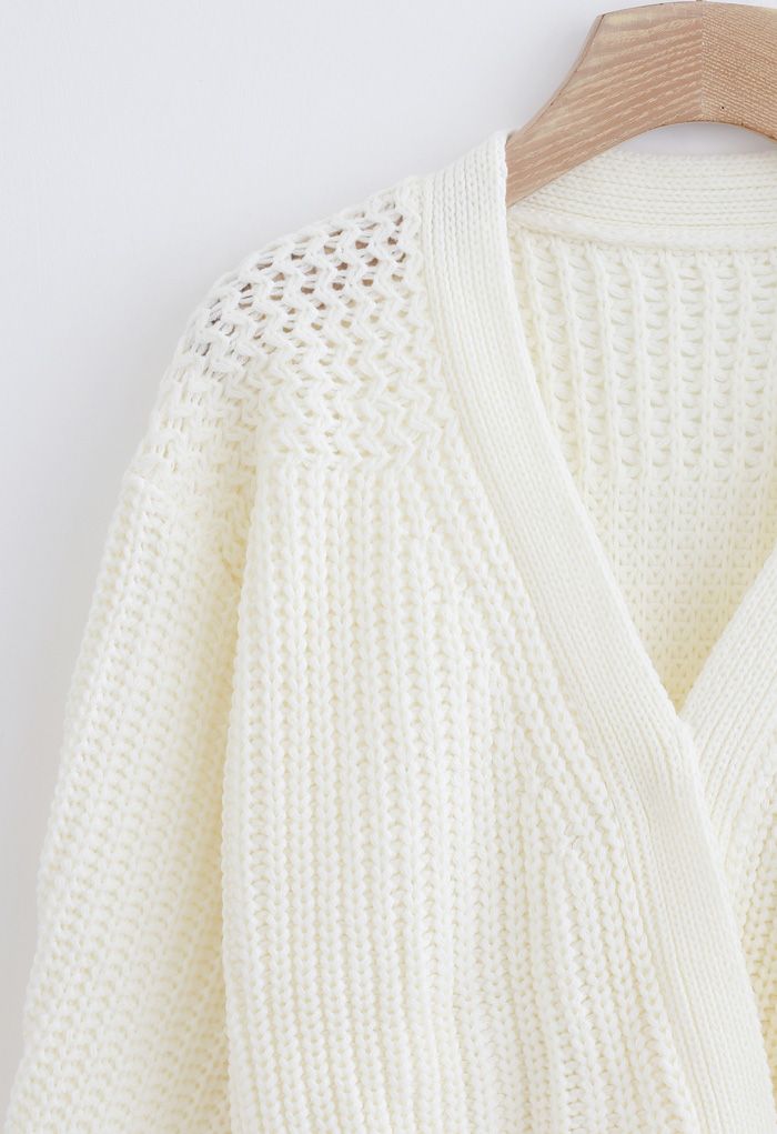 Suéter cruzado de punto grueso con lazo en blanco