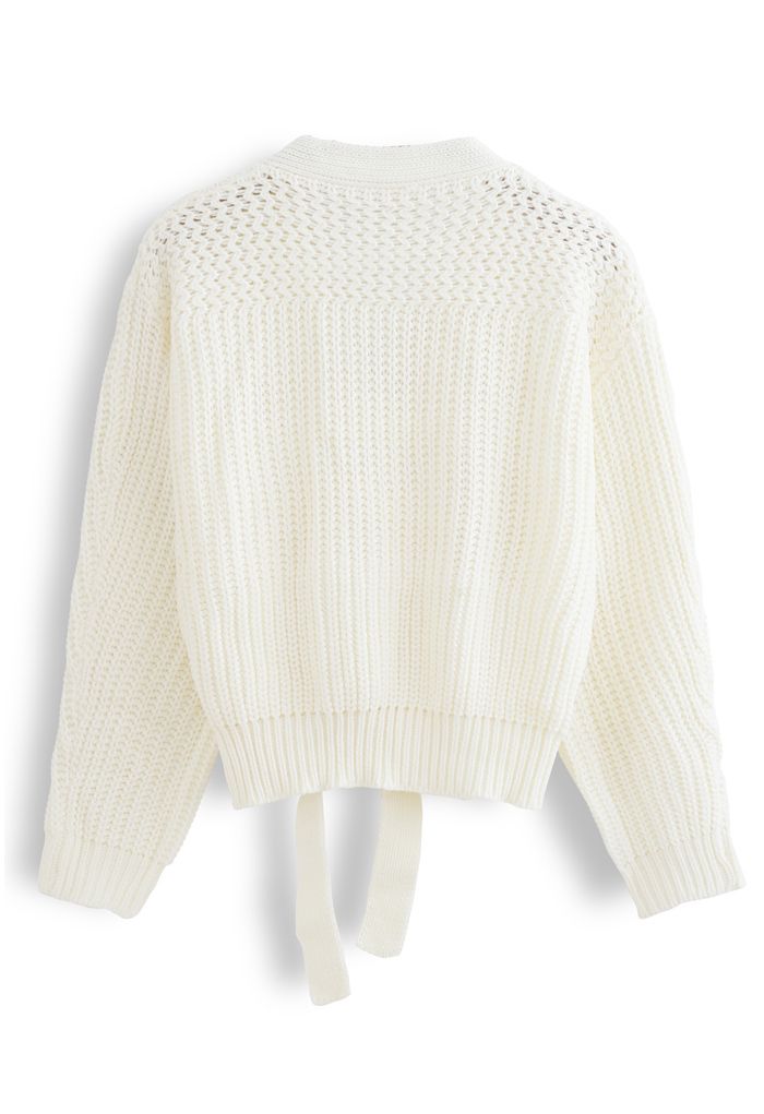 Suéter cruzado de punto grueso con lazo en blanco