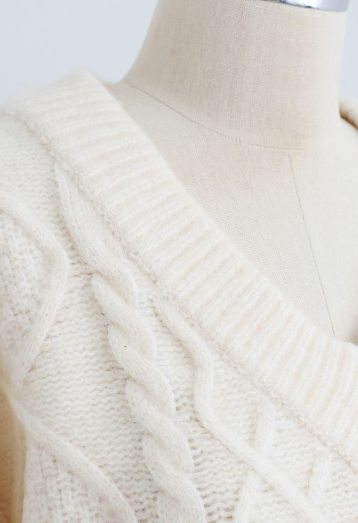 Suéter corto con cuello en V y tejido trenzado con lazo en la espalda en color crema