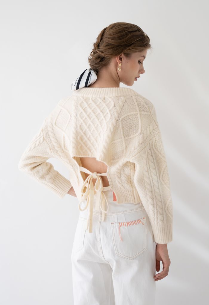 Suéter corto con cuello en V y tejido trenzado con lazo en la espalda en color crema