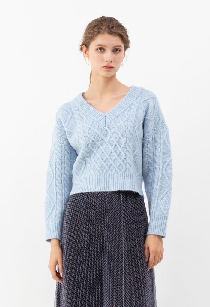 Suéter corto con cuello en V y tejido trenzado con lazo en la espalda en azul