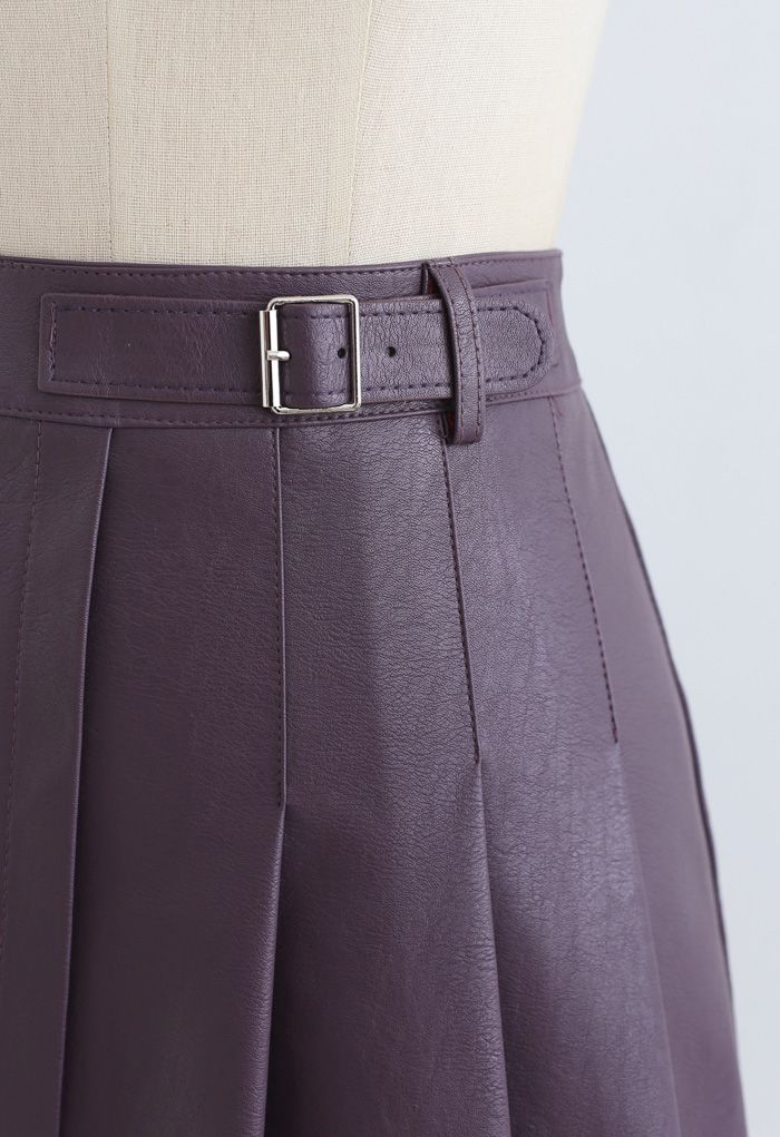 Minifalda plisada de cuero sintético con detalle de cinturón en morado