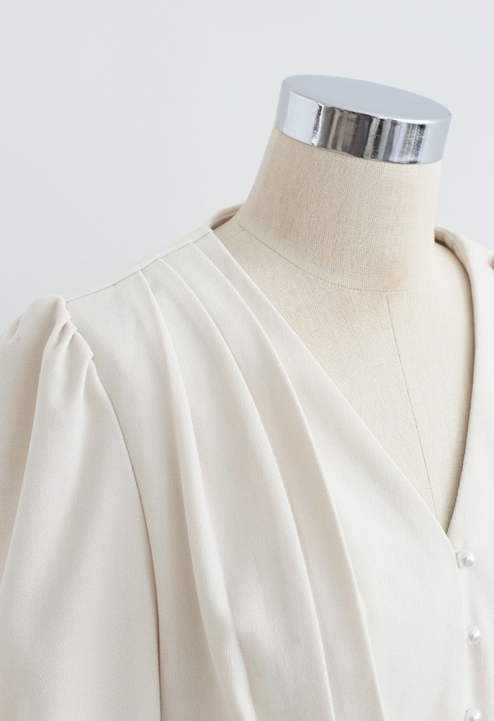 Top corto plisado con cuello en V y botones de perlas en color crema