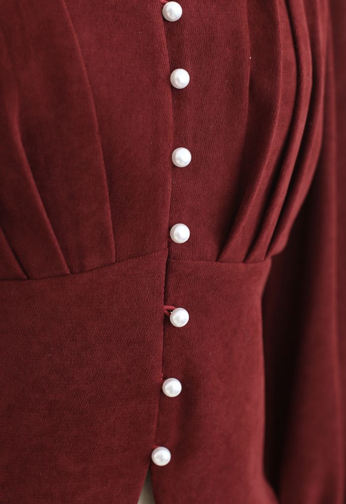 Top corto plisado con cuello en V y botones de perlas en rojo