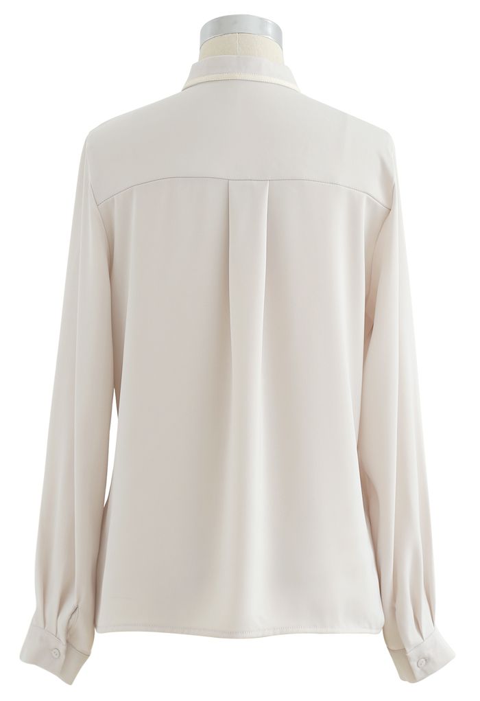 Camisa de satén con cuello de malla y lazo en color crema