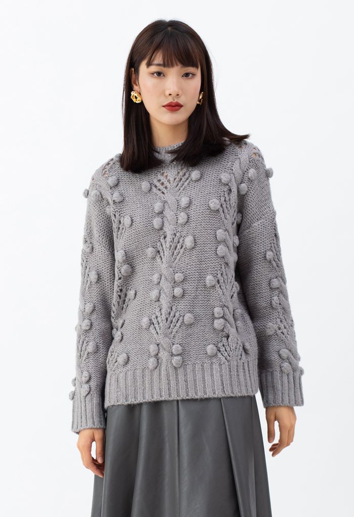 Suéter de punto con ojales y pompones de ochos en gris