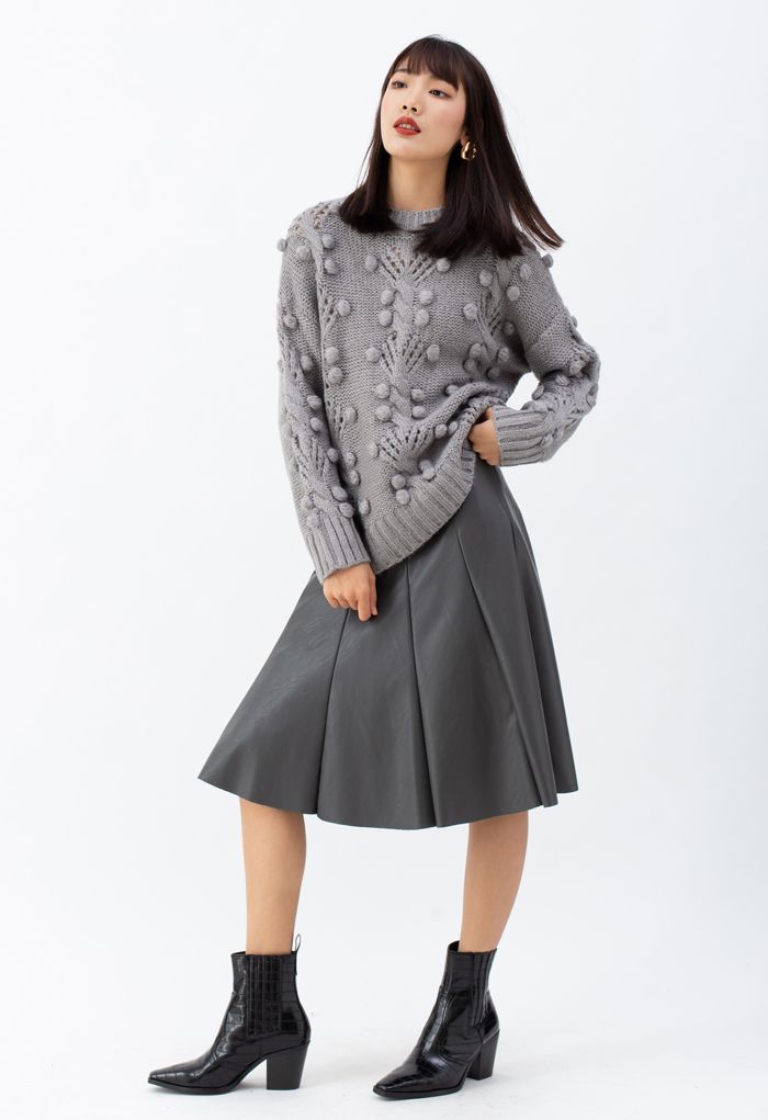 Suéter de punto con ojales y pompones de ochos en gris