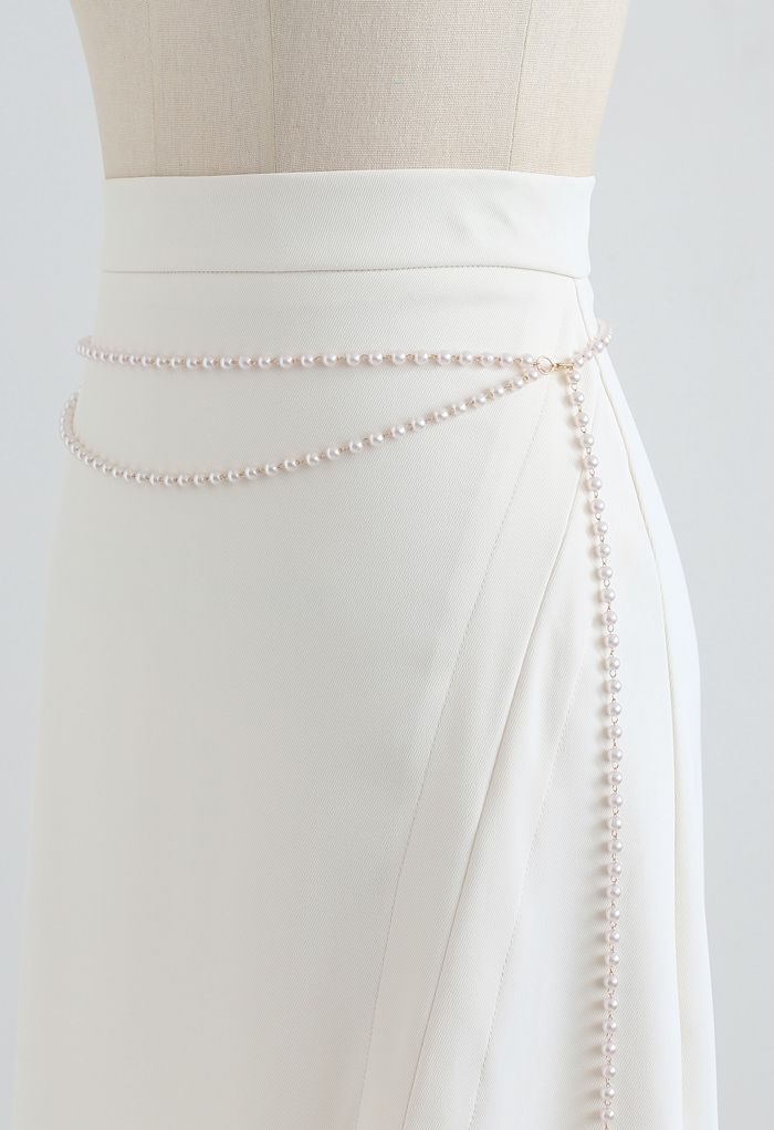 Falda midi con abertura delantera y cadena de perlas en color crema