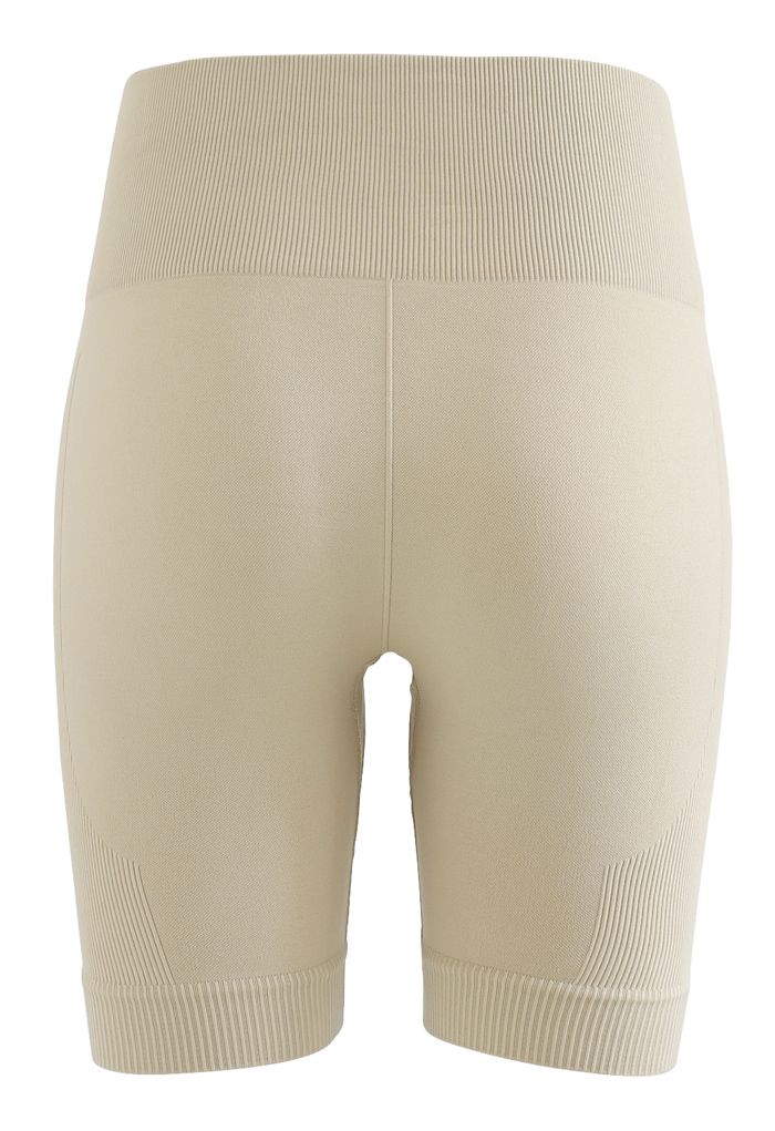 Conjunto de top deportivo corto con cremallera en la parte delantera y pantalón corto tipo legging en camello