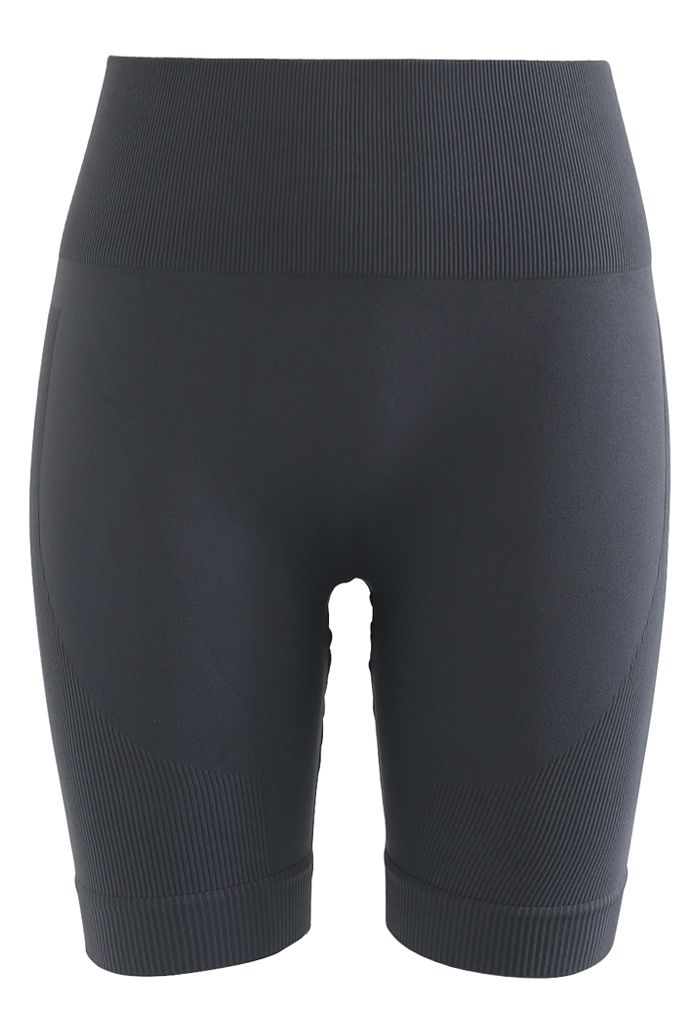 Conjunto de top deportivo corto con cremallera en la parte delantera y pantalones cortos tipo legging en color humo