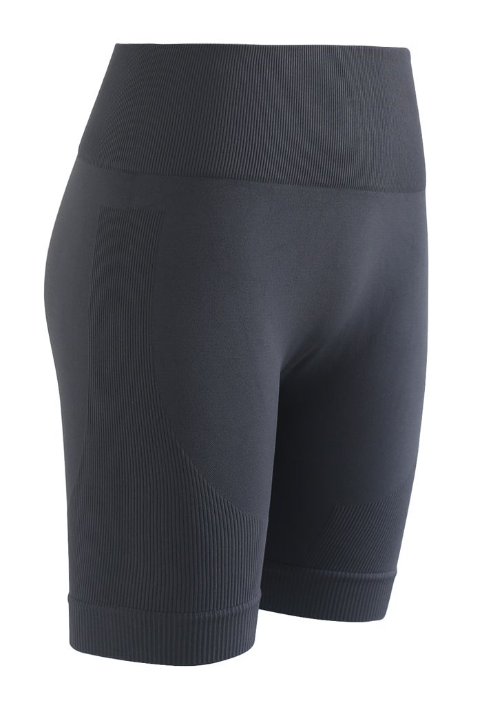 Conjunto de top deportivo corto con cremallera en la parte delantera y pantalones cortos tipo legging en color humo