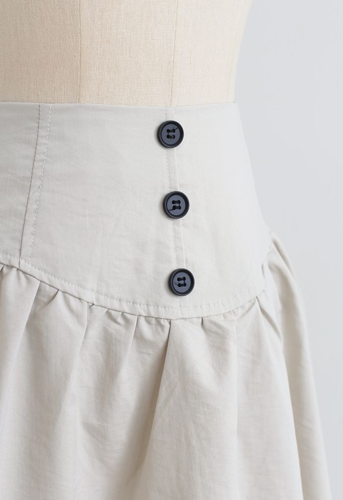 Minifalda de talle alto con ribete de botones en marfil