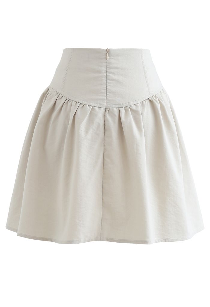 Minifalda de talle alto con ribete de botones en marfil