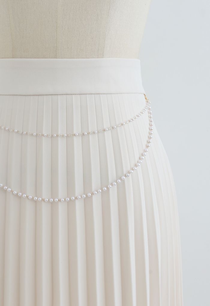 Falda midi plisada con cadena drapeada en color crema