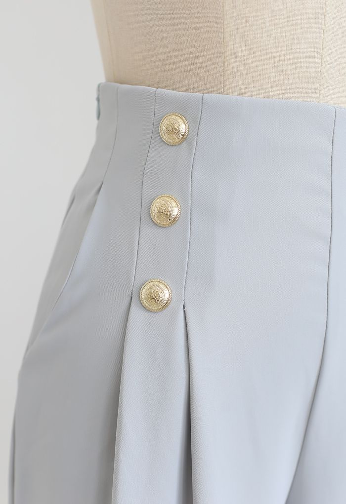 Pantalón plisado decorado con botones dorados en azul claro