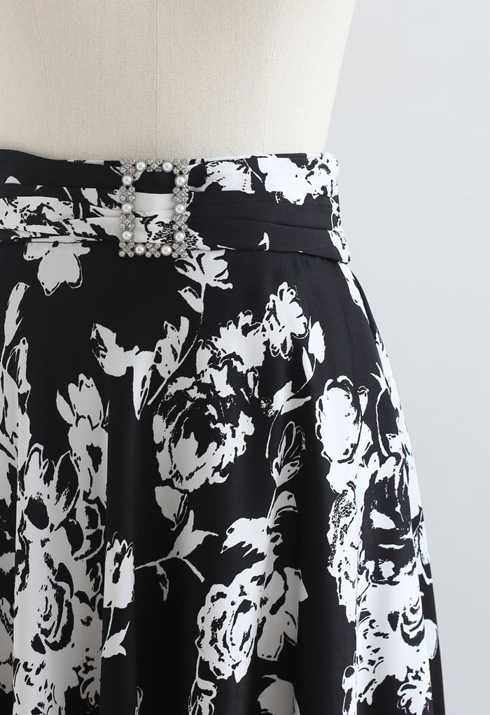 Falda a media pierna con estampado floral y boceto con detalle de broche en negro