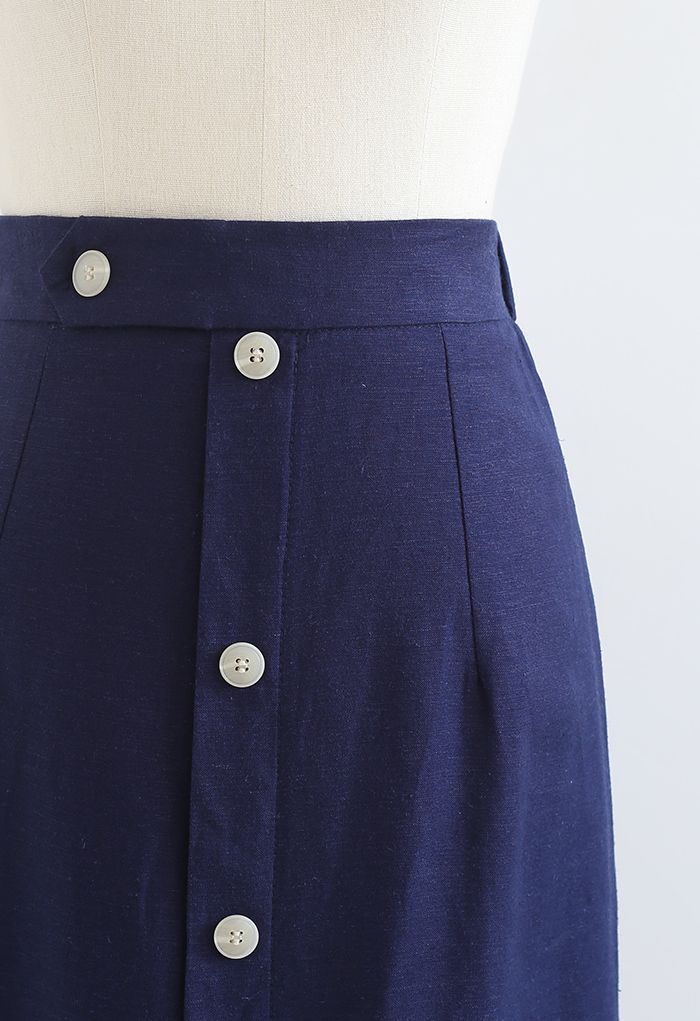 Falda a media pierna adornada con botones y abertura delantera en azul marino