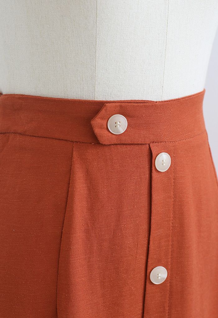 Falda a media pierna adornada con botones y abertura delantera en naranja