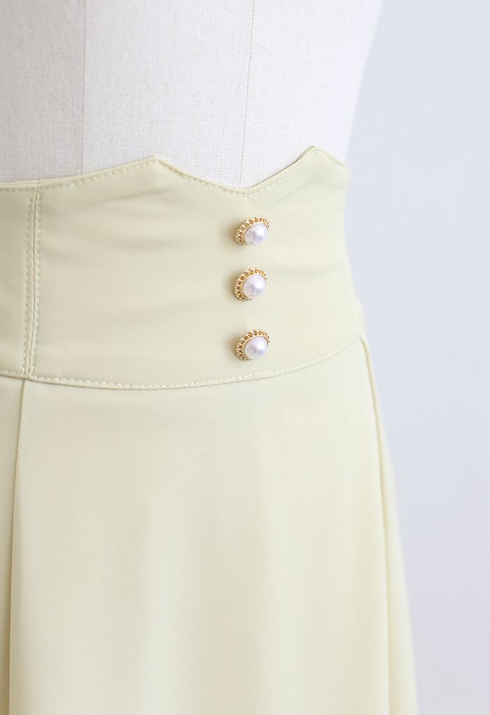 Falda midi acampanada con detalle de costuras en la cintura nacarada en amarillo claro