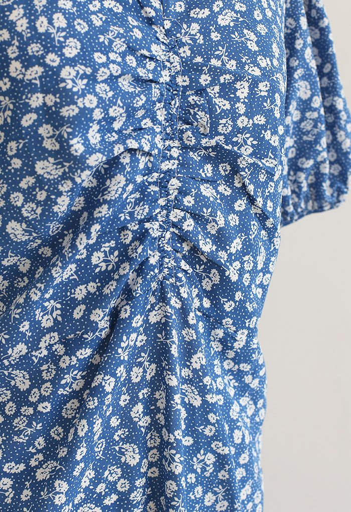 Vestido midi fruncido con estampado floral y detalle recortado en azul
