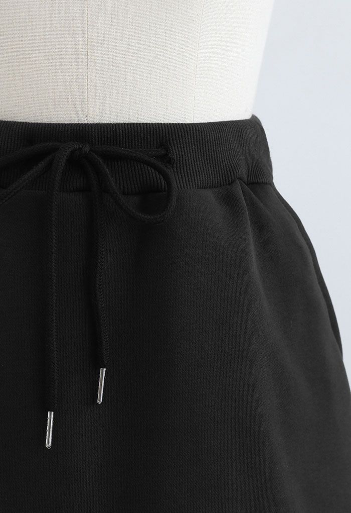 Minifalda pantalón de algodón con bolsillo con cordón en negro