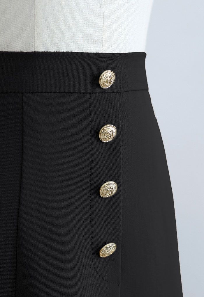 Falda midi con abertura frontal y ribete de botones dorados en negro