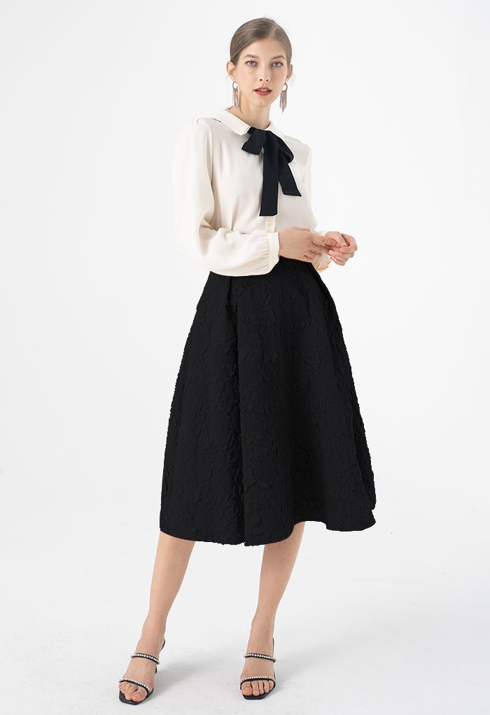 Falda midi plisada con estampado de girasol en negro