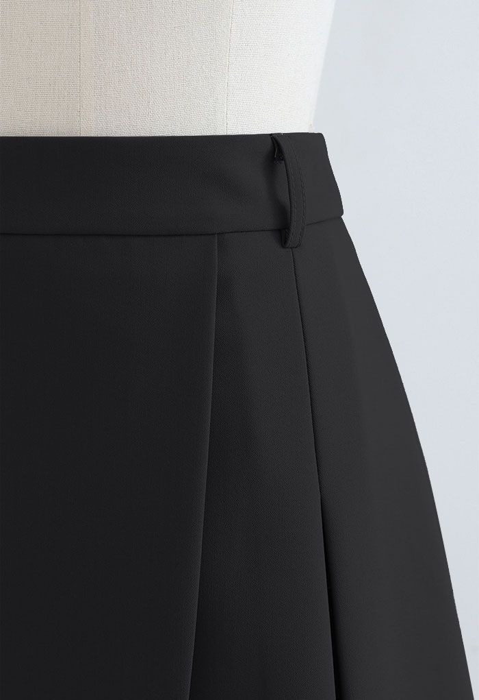 Minifalda negra con cintura abotonada y solapa en la parte delantera