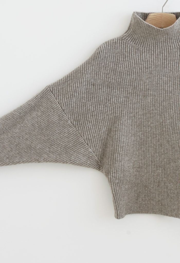 Suéter de punto acanalado con cuello alto y mangas de murciélago en color arena