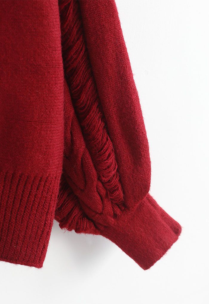 Suéter rojo de punto con cuello alto y detalles con flecos