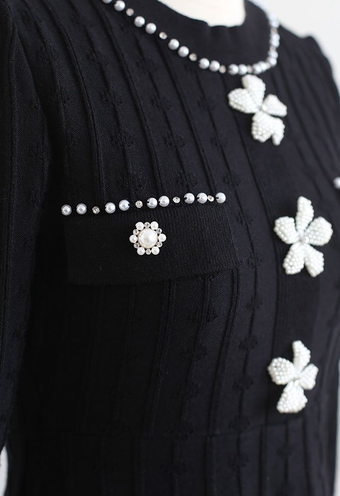 Vestido de punto negro con adornos de flores nacaradas