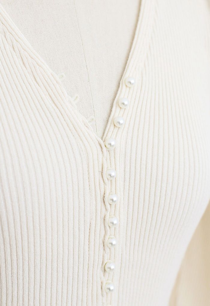 Top de punto ajustado con cuello en V y perlas en color crema