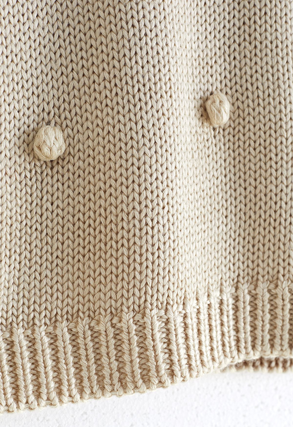 Jersey tejido a mano con pompones en color crema para niños