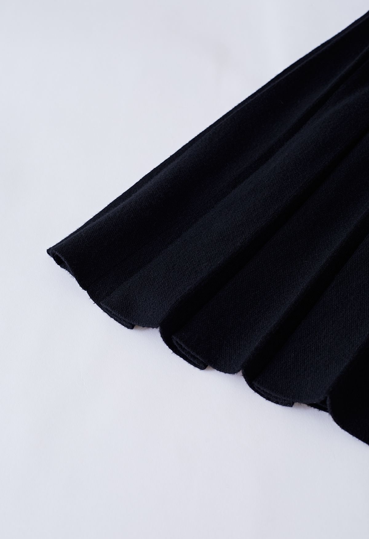 Falda midi de punto plisada con botones en negro