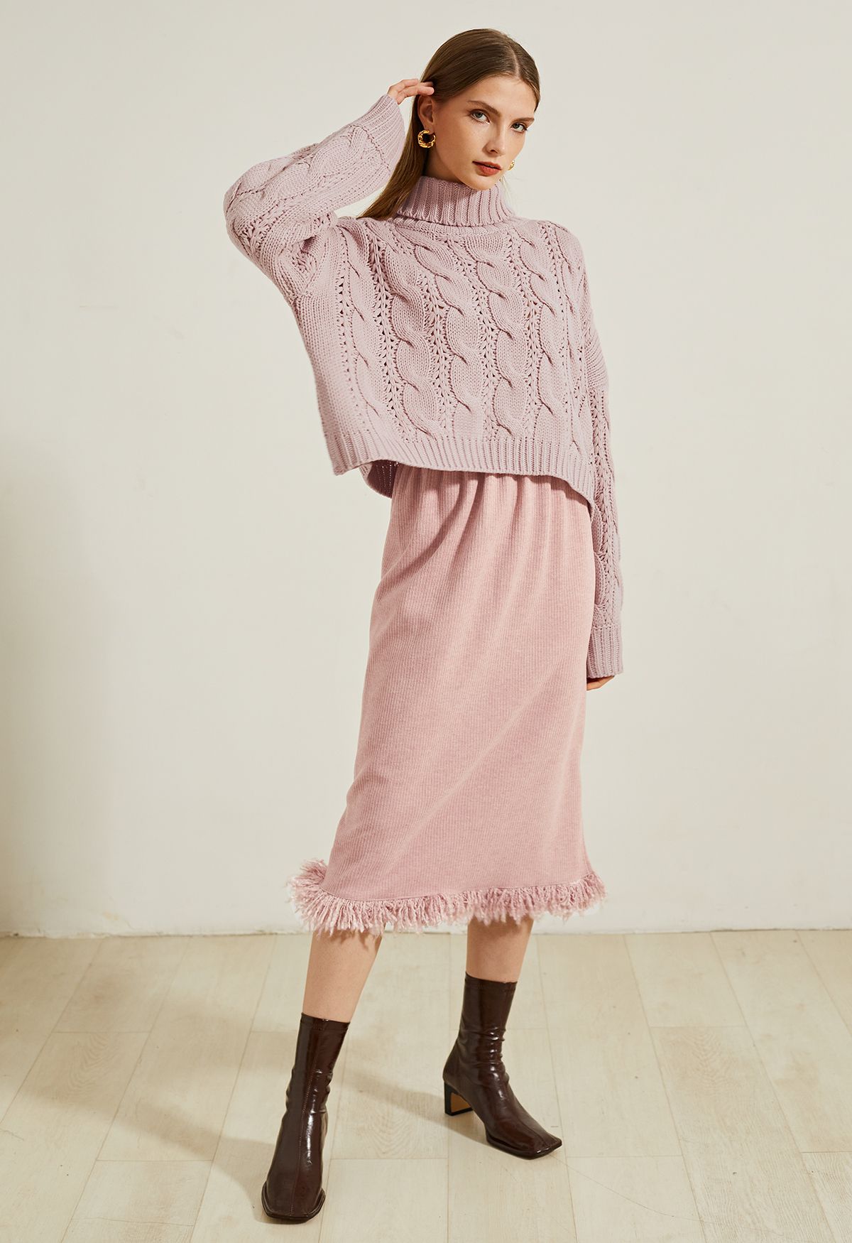 Suéter corto de punto trenzado con cuello alto en rosa