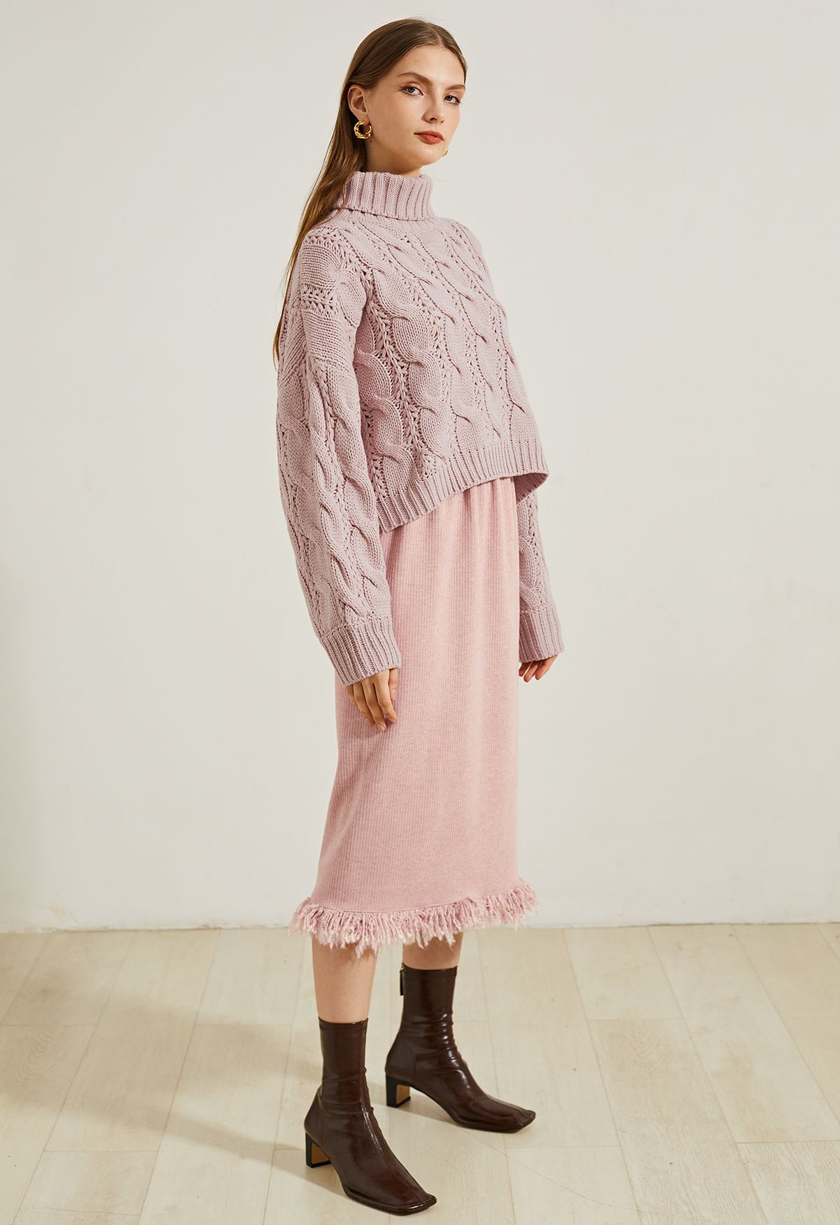 Suéter corto de punto trenzado con cuello alto en rosa