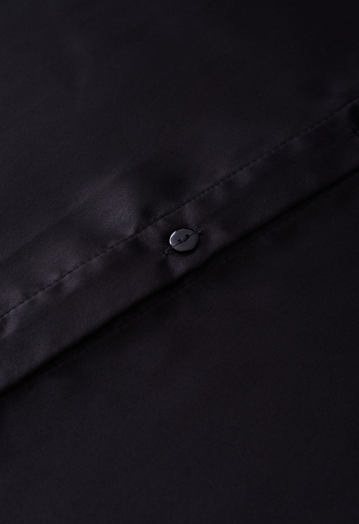 Camisa de satén con ribete de plumas en los puños en negro