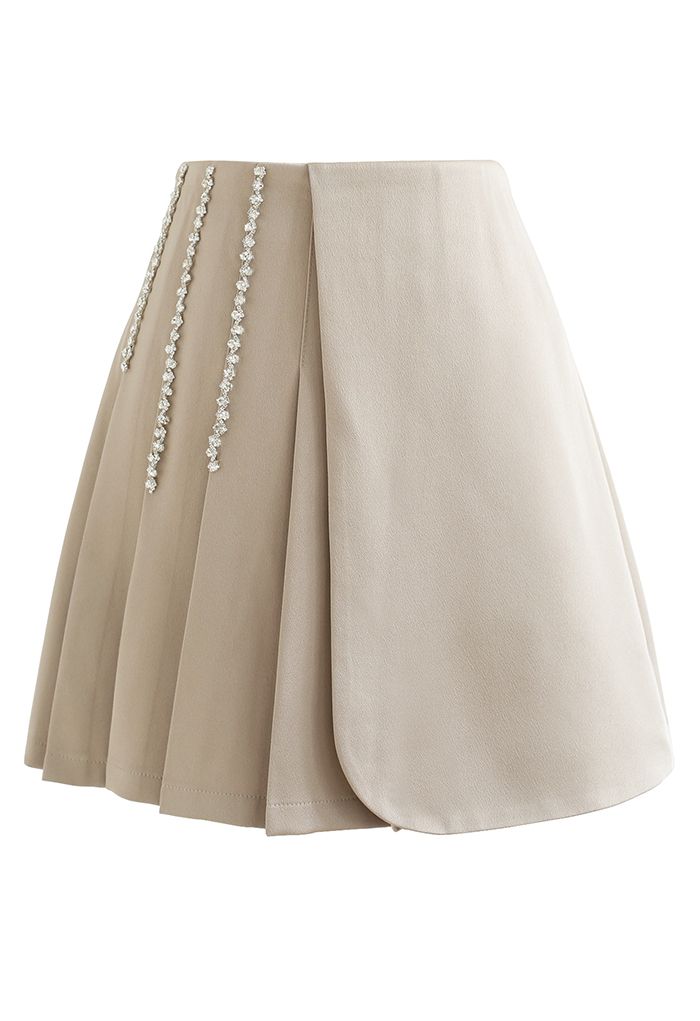 Minifalda con solapa plisada decorada con cadena de cristales en color arena