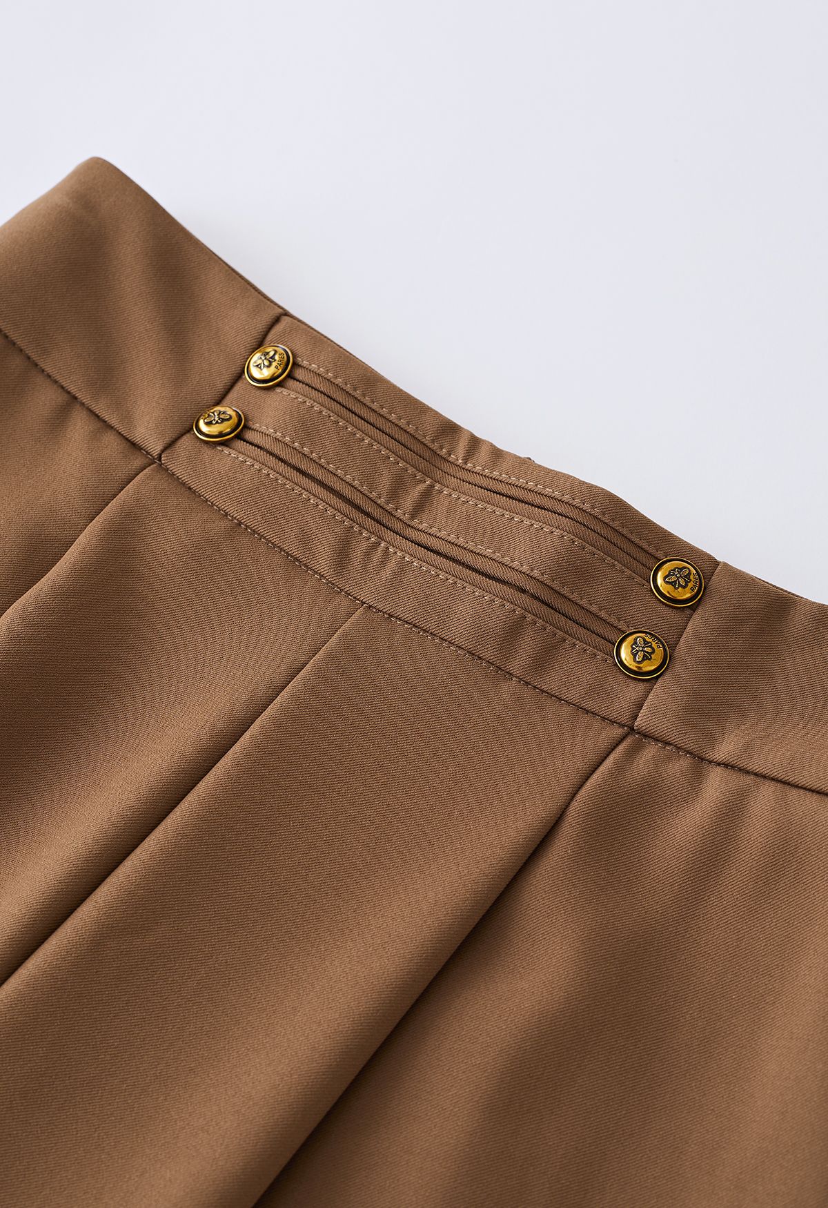 Pantalones anchos con botones dorados en marrón