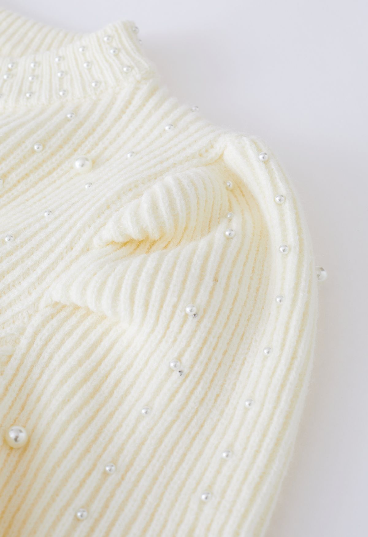 Suéter de punto con mangas abullonadas adornadas con perlas en color crema