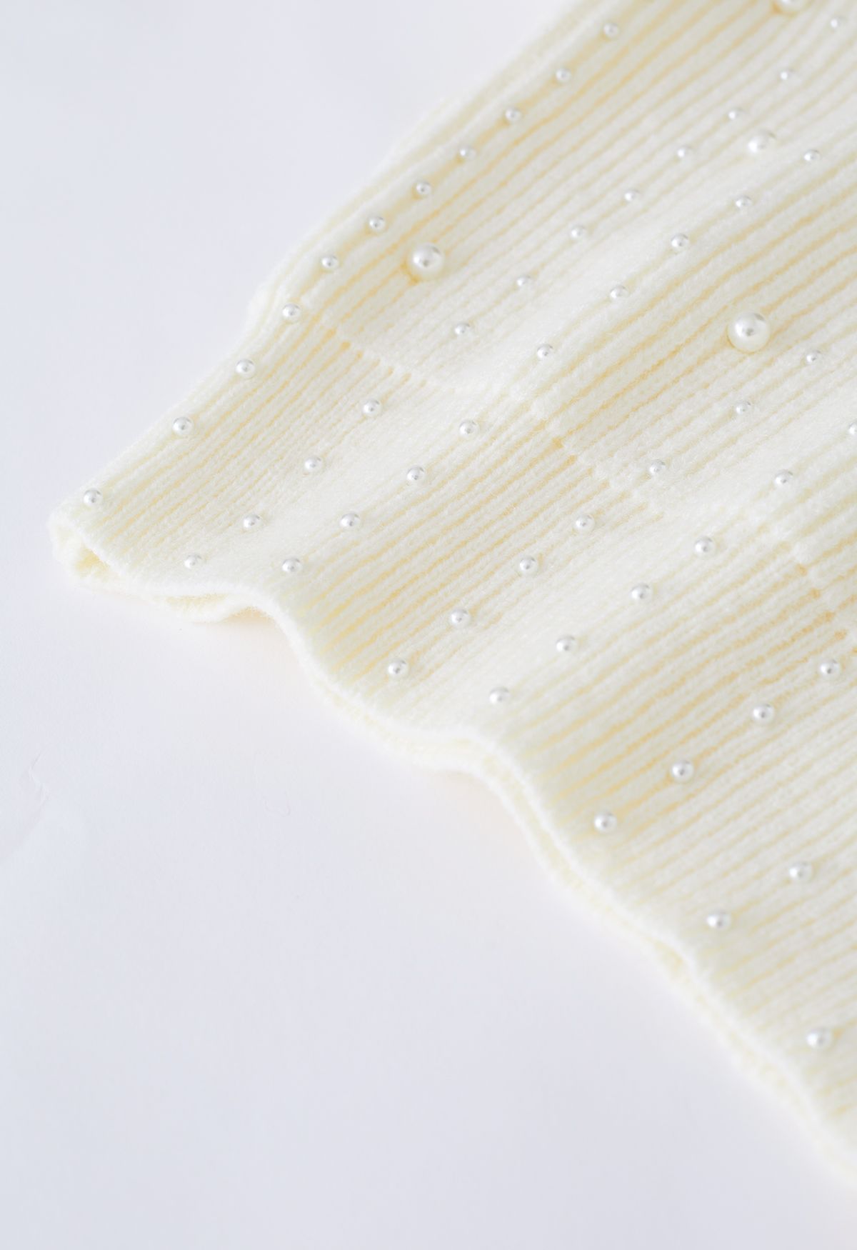 Suéter de punto con mangas abullonadas adornadas con perlas en color crema