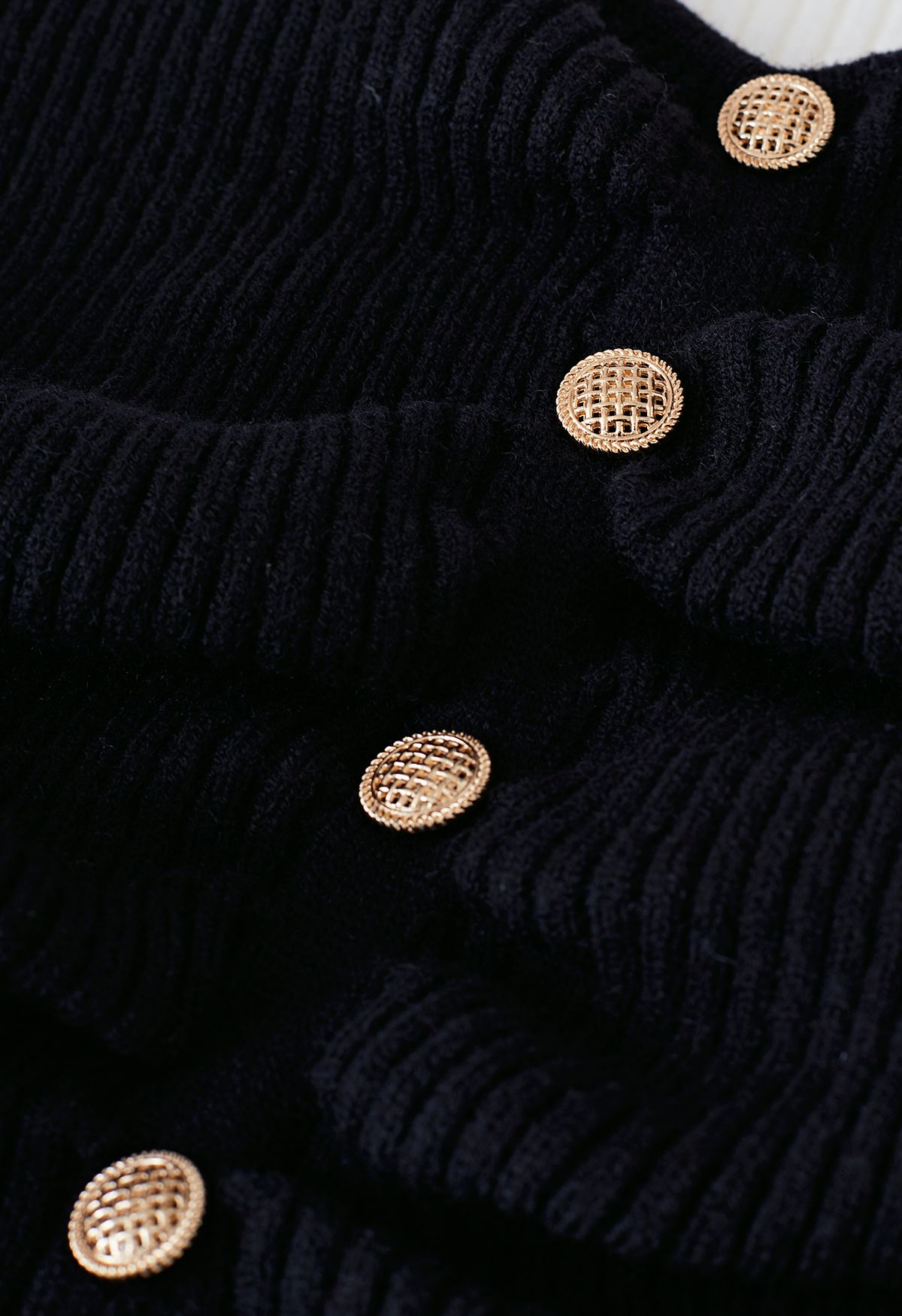 Suéter de punto con mangas abullonadas y botones en contraste en negro