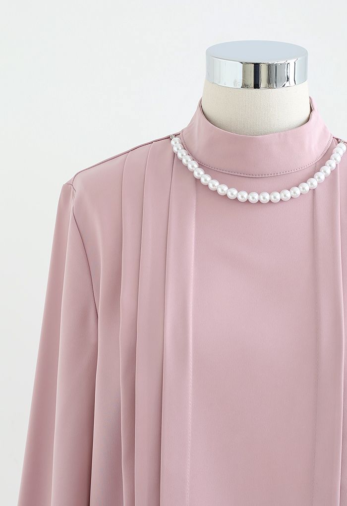 Collar de perlas con camisa fruncida en rosa