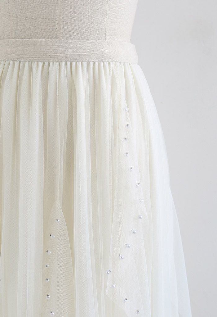 Falda de tul plisada con decoración de cuentas dispersas en color crema
